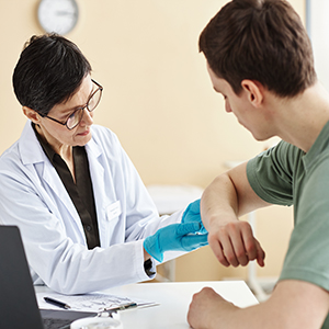 Doctor examines a patient's arm while discussing Lupus and flare-ups for SSDI claims